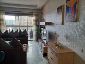A modern living room with a sofa set, a wooden console table, and a TV.