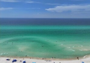 A beach with clear turquoise water, people swimming, and beach umbrellas. - Kings Cove! 2 Private Pool! 300yds to Beach (Panama City Beach)