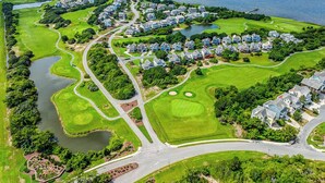Ett flygbildsfoto av ett bostadsområde med hus, vägar och en golfbana.