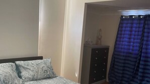A bedroom with a bed, a ceiling fan, a wardrobe, and a window with curtains. - Room-salt and Sea Renity On Milton (Russell Island)