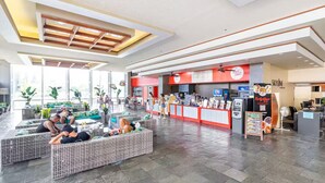 A spacious indoor area with seating arrangements and a food counter. - Waikiki Seaside Luxury King Condo with Balcony (Honolulu)