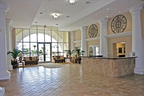 A spacious lobby with a high ceiling, large windows, and a reception desk. - Ariel Dunes II 607 (Miramar Beach)