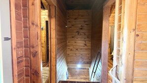 Ein holzgetäfelter Flur mit Holzboden und -wänden, der zu einer Treppe führt.