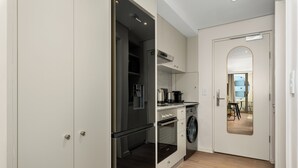 Una cocina compacta con lavadora, horno integrado y microondas.