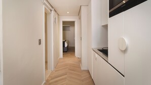 Una cucina moderna con mobili bianchi, forno integrato e microonde.