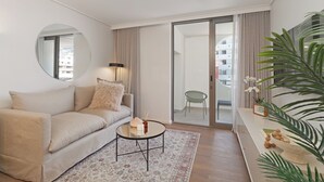 Ein modernes Wohnzimmer mit einer Couch, einem runden Couchtisch und einem großen Spiegel.