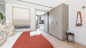 A modern bedroom with a large bed, a red rug, and a minimalist design. - One Rosebank Premium Luxe Apartment (Johannesburg)