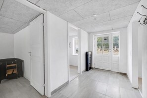 Ein geräumiger Raum mit großem Kleiderschrank, einer Tür zu einem Balkon und einer Decke mit Einbuchtungslichtern.