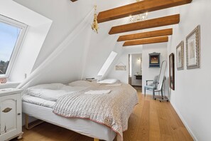 A bedroom with a bed, a nightstand, a chair, and a desk.