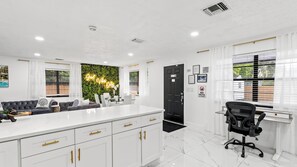 A modern kitchen with white cabinets, a black countertop, and a built-in stove.