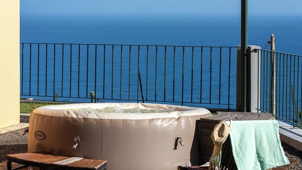 Ein Whirlpool auf einem Balkon mit Meerblick.