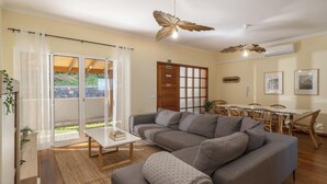 Ein Wohnzimmer mit einer Couch, einem Couchtisch und einem Essbereich mit Stühlen und einem Tisch.