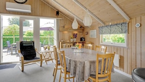 A wooden interior with a round table, chairs, a clock, and a view of the outdoors. - 3 bedroom beautiful home in Hejls (Hejls)