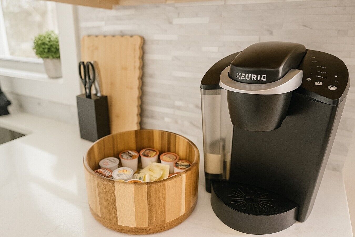 Eine Kaffeemaschine mit einer Holbschale voller Kapseln auf einer Küchenarbeitsfläche.