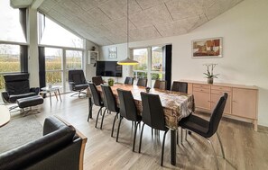 A spacious dining area with a long table, multiple chairs, a television, and a cabinet. - Lovely home in Haderslev with sauna (Haderslev)