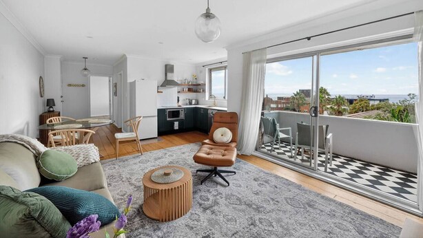 A modern apartment with a kitchen, dining area, and a balcony with a checkered floor. - Coogee Oasis Ocean Outlooks near the Beach (Coogee)