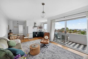 Un apartamento moderno con cocina, comedor y balcón con suelo a cuadros.
