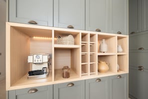 A kitchen with a coffee machine, shelves with kitchenware, and a built-in scale. - Villa Analidia Comfort (Koridallos)