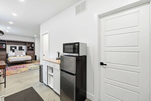 A compact kitchen with a refrigerator, microwave, and a small countertop. - Modern studio apartment with dedicated workspace! (Louisville)