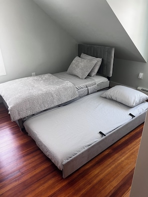 A bedroom with a loft bed, a bedside table, and a nightstand.