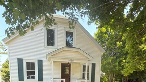 A two-story house with a front porch, a mailbox, and a well-maintained lawn. - Charming Stylish & Cozy Coastal Retreat (Rockport)