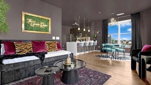 Una sala de estar moderna con sofá, mesa de centro y un comedor con sillas.