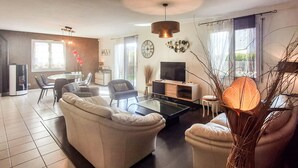 Un salon moderne comprenant un canapé, une table basse, un téléviseur et des objets de décoration.