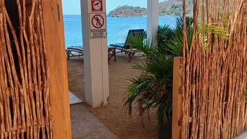Une propriété située en bord de mer, dotée d’un espace salon couvert, d’un panneau indiquant qu’il s’agit d’une propriété privée et offrant une vue sur la mer.