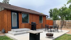 A backyard with a barbecue grill, a fire pit, and a dining area with chairs and a table. - Newley Remodeled  3-bedroom house with AC in Grand Junction. (Grand Junction)