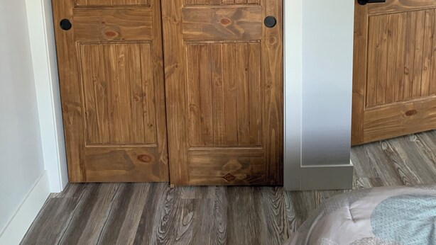 A room with a wooden wardrobe and a bed with a patterned bedspread. - Newley Remodeled  3-bedroom house with AC in Grand Junction. (Grand Junction)