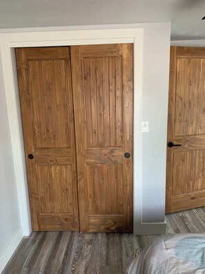 Ein Zimmer mit einem Holzschrank und einem Bett mit gemustertem Überwurf.