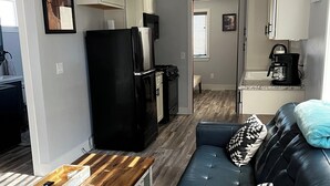 A compact living space with a kitchenette, a sofa, and a coffee maker. - Newley Remodeled  3-bedroom house with AC in Grand Junction. (Grand Junction)