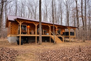 Eine Blockhütte mit Veranda, Treppe und einer Terrassenfläche.