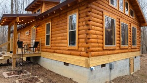 A log cabin with a deck, a fireplace, and a chimney. - Restful Haven - Hot Tub at Secluded Modern Cabin | Private Trails (Altamont)