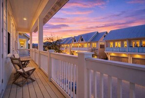 A waterfront property with a covered deck, multiple buildings, and a sunset view. - Sandbar Sunset by Stay on 30a (Inlet Beach)