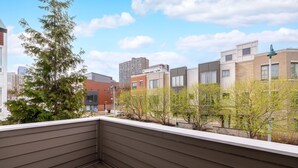 A balcony with a view of neighboring buildings and trees. - Luxury Downtown Townhome w/ Private Garage Unit 12 (Cleveland)