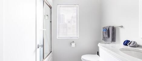 Une salle de bain moderne équipée de toilettes, d’un lavabo et d’une douche.