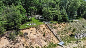 A house with a patio and a steep, rocky hillside.