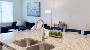 Una cucina moderna con piani in granito, lavello in acciaio inossidabile e isola integrata.