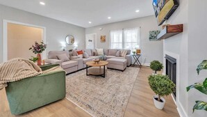 Una sala moderna con un sofá modular, una mesa de centro y una chimenea.