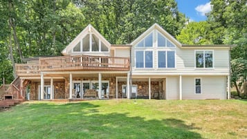 A two-story house with a covered porch and a stone exterior.