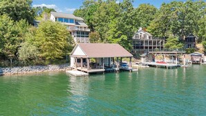 A waterfront property with a dock, a covered pavilion, and multiple houses. - Lake Allure - Private Dock, Indoor Pool, and Hot Tub (Huddleston)