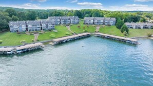 Un hôtel situé au bord d’un lac, composé de plusieurs bâtiments, avec un quai et un bateau.