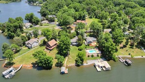 An aerial view of a lakeside community with houses, a dock, and a swimming pool. - Lakeside Sunsets - Private Dock, Hot Tub & Firepit (Moneta)