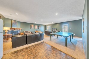A spacious living room with a pool table, a sofa, and a fireplace. - Whisper Haven - Private Dock & Pet Friendly (Moneta)
