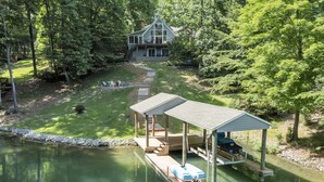 A lakeside cabin with a dock and a covered deck area. - Lake Pleasant - Lakefront, Private Dock, Game Room (Huddleston)