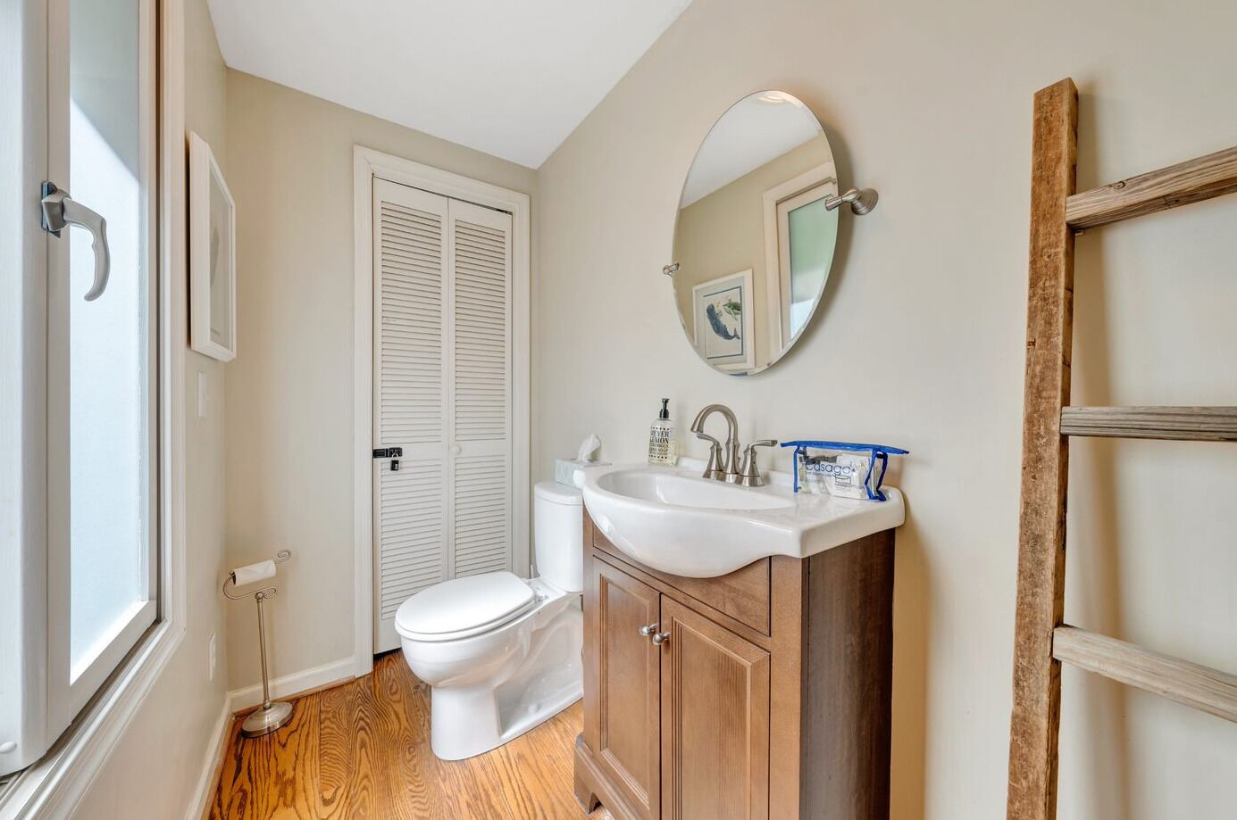 Un baño con inodoro, lavabo y armarios de madera.