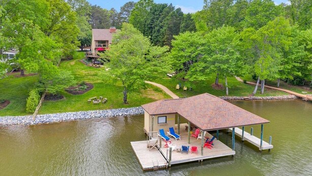 A lakeside cabin with a dock, outdoor seating, and a well-maintained lawn. - Dancing Water - Sleeps 10, Private Dock, Game Room & Hot Tub (Moneta)