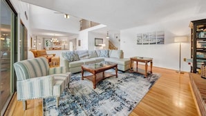 Ein geräumiges Wohnzimmer mit einem großen Sofa, einem Couchtisch und einer Treppe, die zu einer oberen Etage führt.