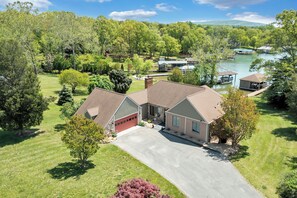 A residential property with a large garage, a covered driveway, and a lake view. - Stargaze - Lakefront With Private Dock (Huddleston)